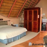 “Double bed in chalet at Didima Camp – cosy mountain accommodation in the Drakensberg, KwaZulu-Natal, South Africa