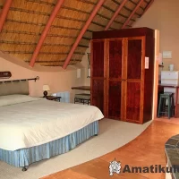 “Double bed in chalet at Didima Camp – cosy mountain accommodation in the Drakensberg, KwaZulu-Natal, South Africa