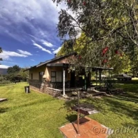 Front view of a 4-bed self-catering chalet at Injisuthi Camp with mountain backdrop in the uKhahlamba-Drakensberg Park, South Africa