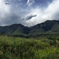 Clouds rolling over the mountains surrounding Injisuthi Camp in uKhahlamba-Drakensberg Park, creating a dramatic and moody landscape in South Africa