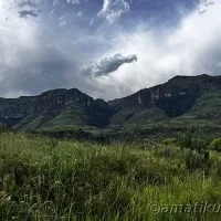 Clouds rolling over the mountains surrounding Injisuthi Camp in uKhahlamba-Drakensberg Park, creating a dramatic and moody landscape in South Africa
