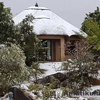 Snow-covered chalets at Thendele Upper Camp with winter views of the Drakensberg Amphitheatre in Royal Natal National Park, South Africa